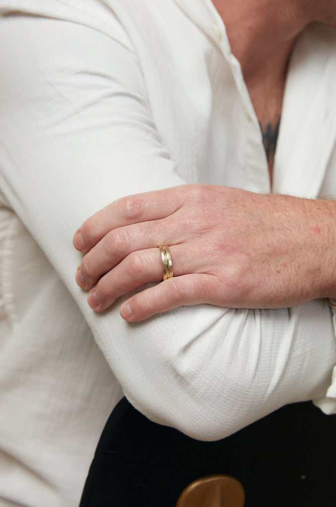 close up of man's hand wearing gold band