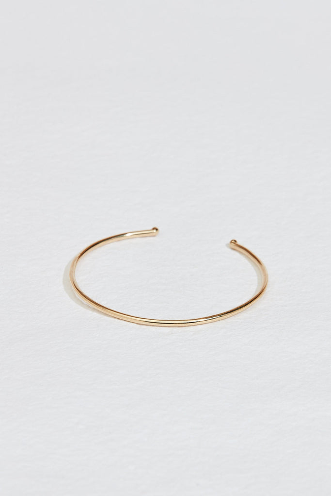 close up of thin gold cuff with knotted ends