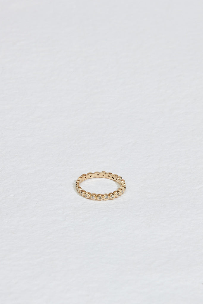 gold band with bezel set round white diamonds