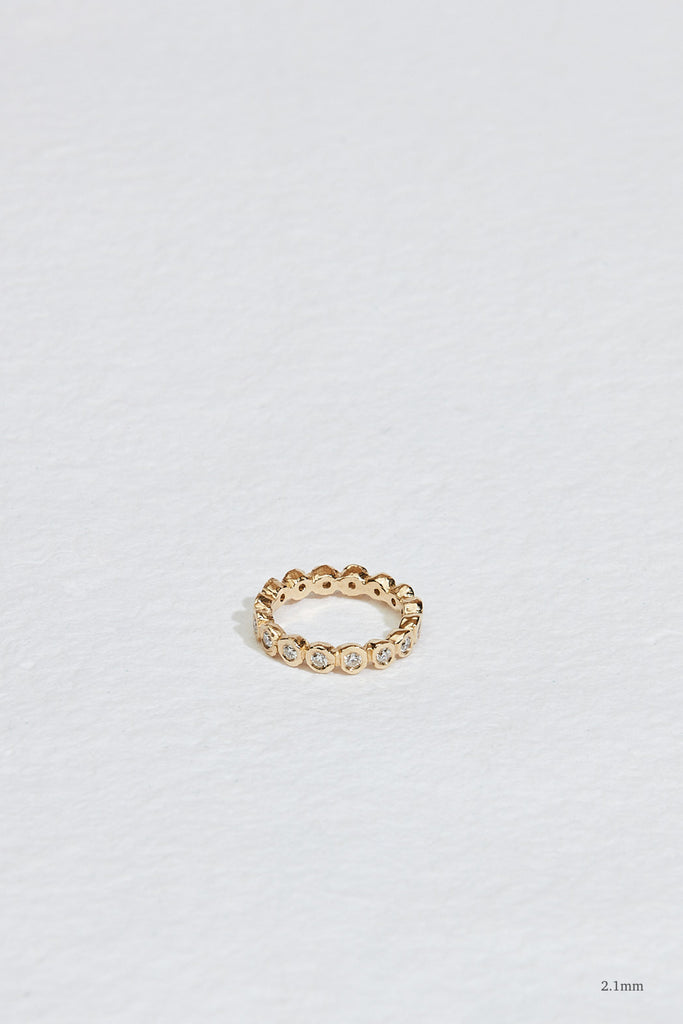 gold eternity band with bezel set round diamonds