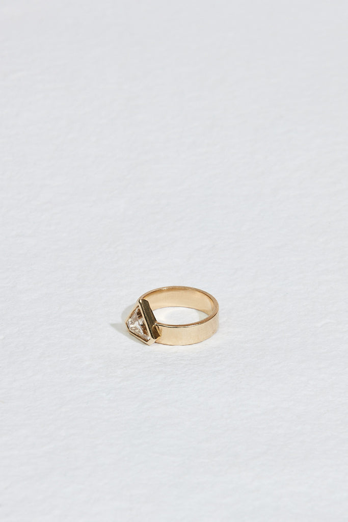 side view of gold band with bezel set shield shaped yellow brown diamond