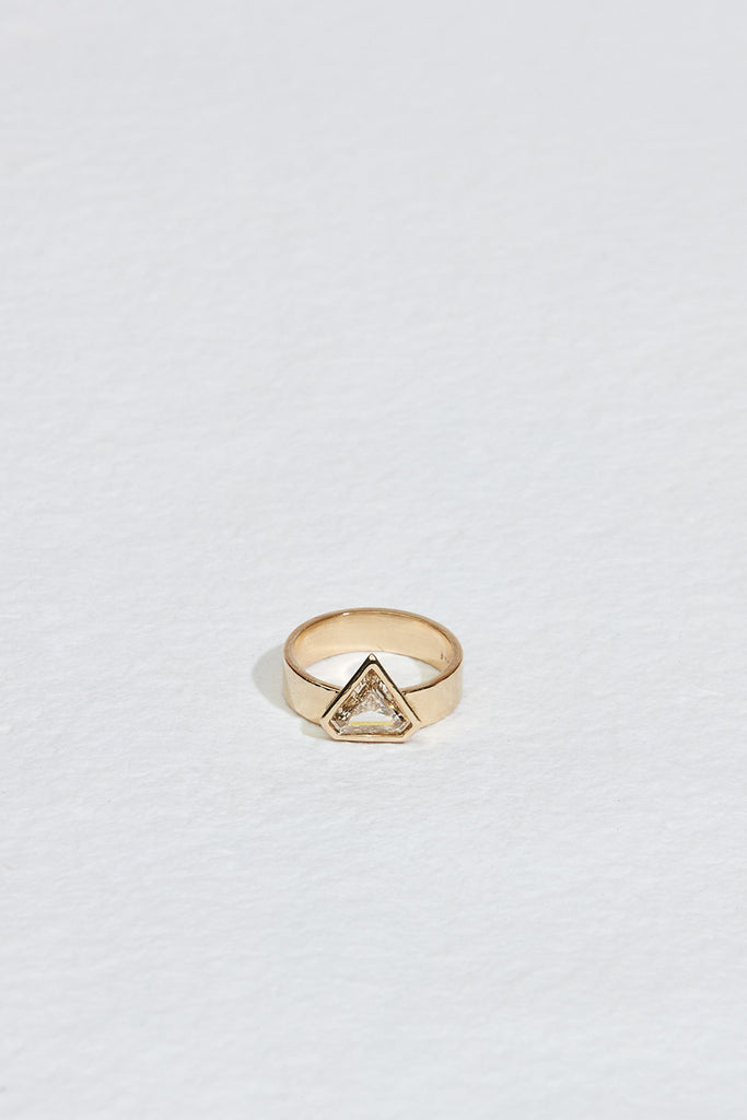 close up of gold band with bezel set shield shaped yellow brown diamond