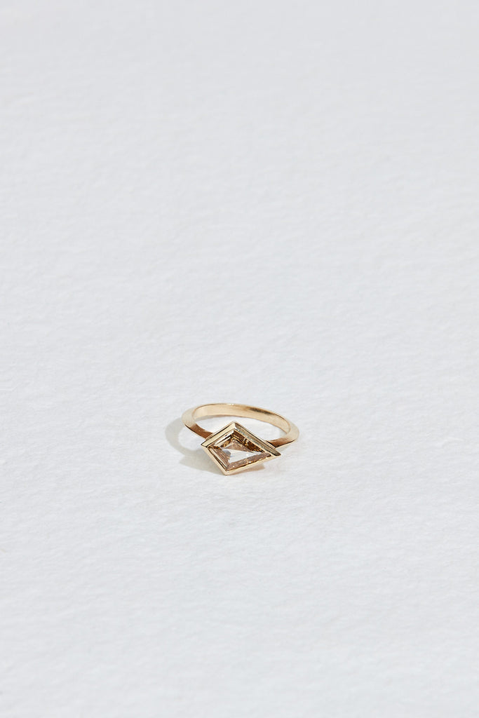 close up of gold band with bezel set yellow brown kite shaped diamond