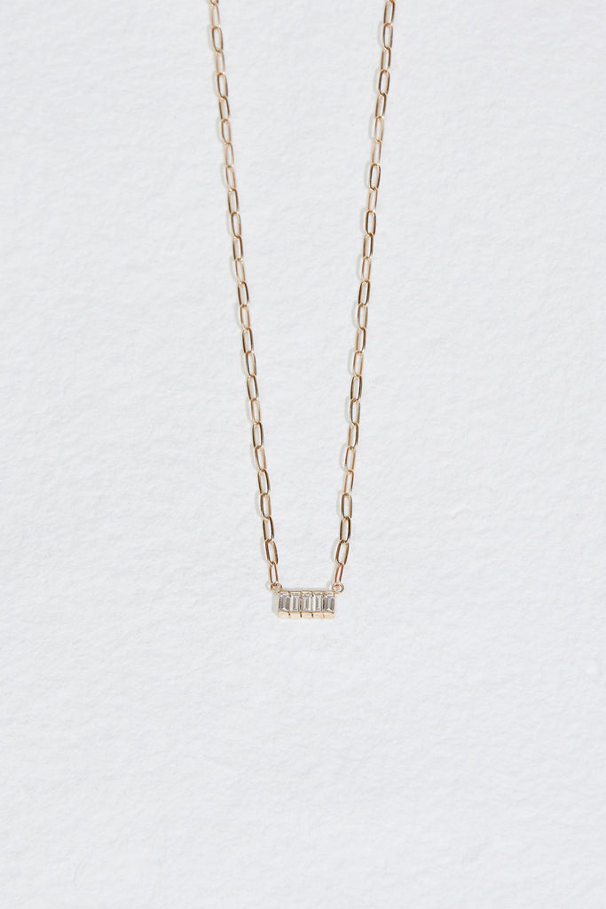 close up of gold cable chain necklace with 5 baguette diamonds