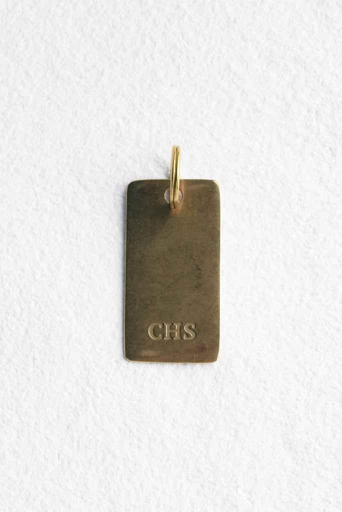 close up of bronze keychain with engraved "chs"