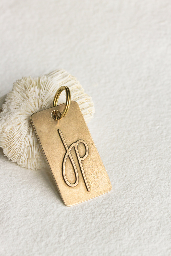 close up of bronze keychain with "JP" on it