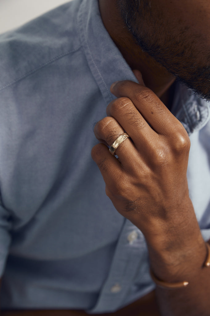 close up of man's hand wearing textured gold band