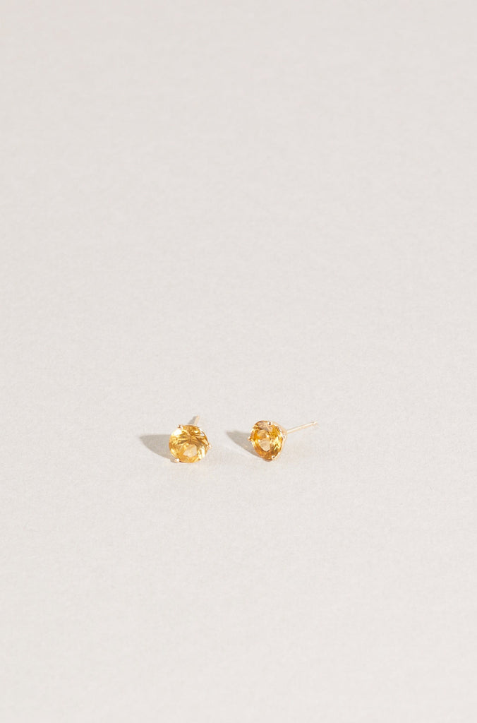 round citrine studs with gold three prong martini setting