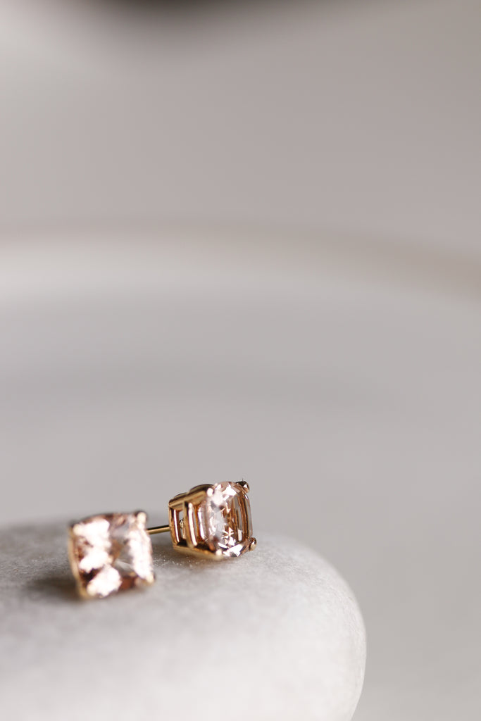 close up side view of gold cushion cut morganite stud earrings
