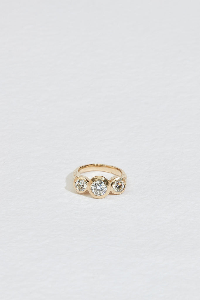 gold ring with three bezel set round white diamonds
