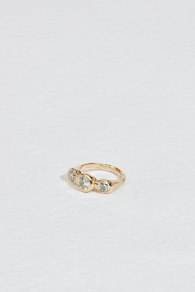 gold ring with three bezel set round white diamonds