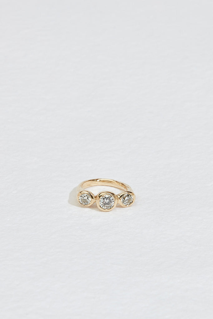 gold ring with three bezel set round white diamonds