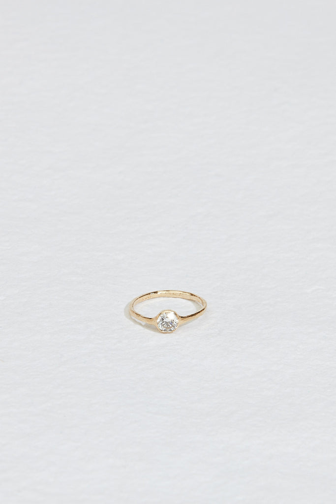 gold ring with bezel set round white diamond