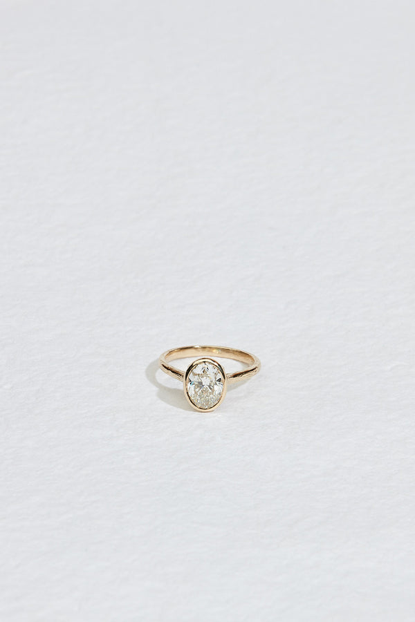 gold ring with bezel set oval white diamond