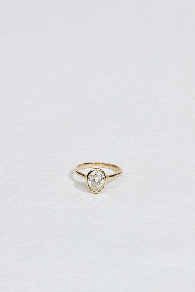 gold ring with bezel set oval white diamond