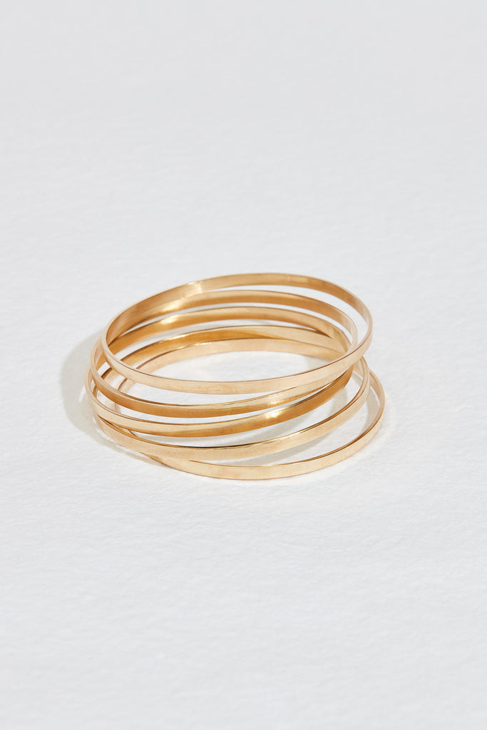 stack of five flat gold bangles