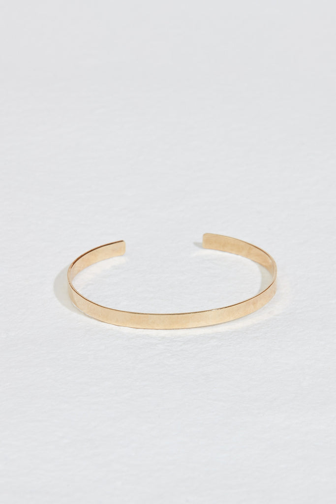 close up of gold flat cuff bracelet