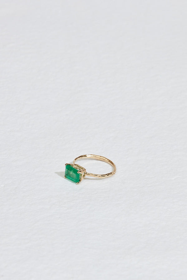 side view of gold four prong twig ring with rectangle emerald