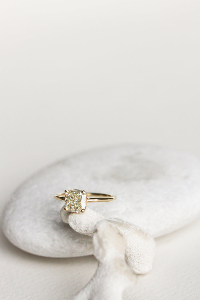 four prong gold ring with cushion cut yellow diamond