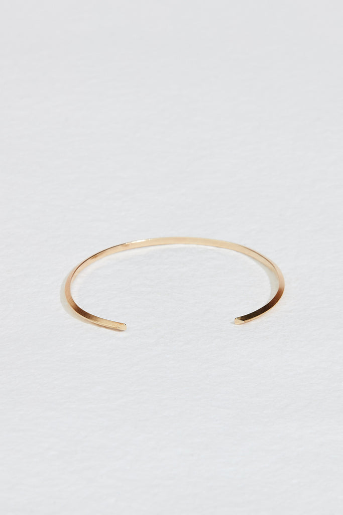 close up of gold cuff bracelet with knife edge detail