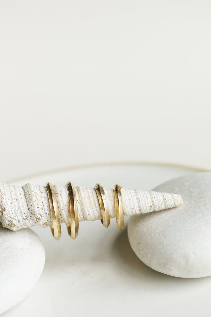 close up of large and small gold knife edge cut hoop earrings