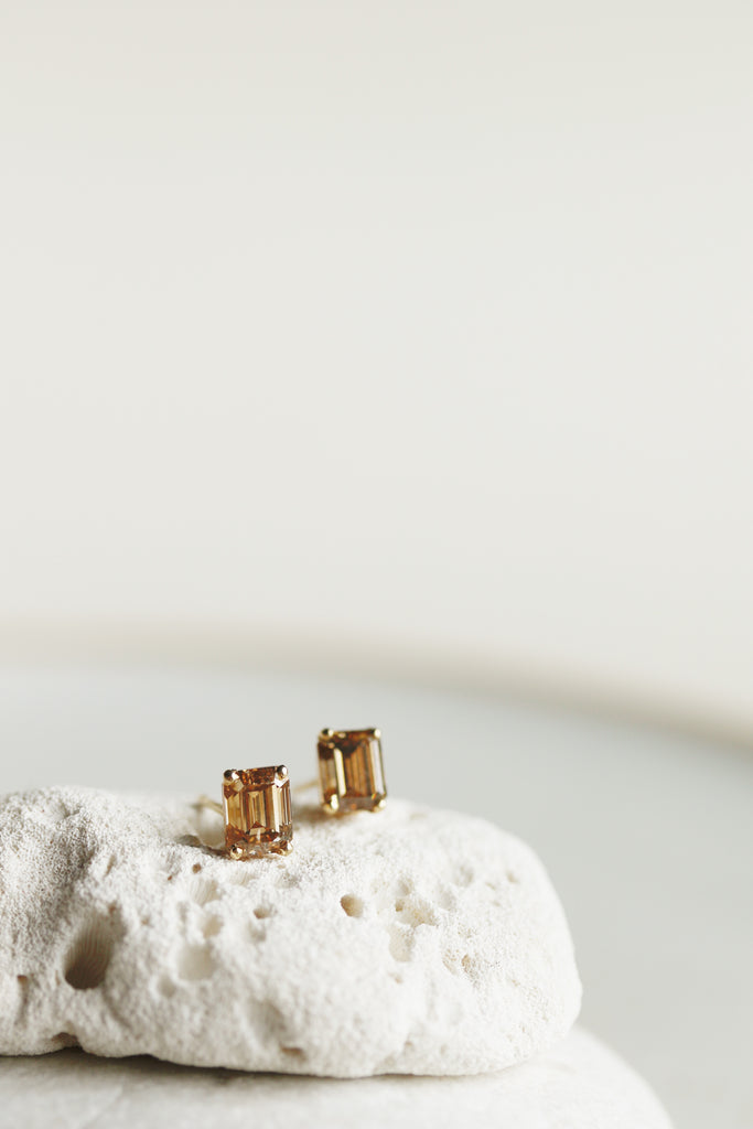 close up of emerald cut champagne diamond studs