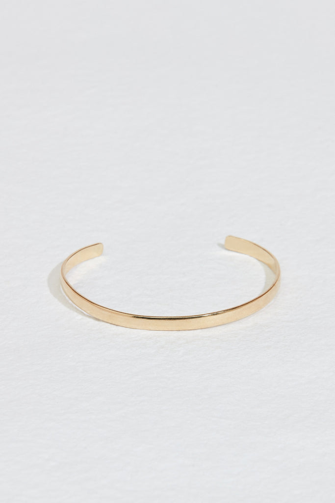 close up of gold cuff bracelet with rounded edges