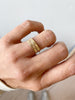 close up of hand wearing two gold rings with hand engraved front plates