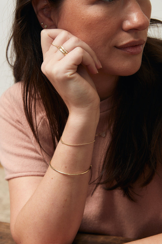 woman wearing gold bookend cuff bracelet alongside other gold jewelry