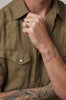 close up of man wearing gold ball chain bracelet alongside gold ring