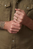 close up of man's hand wearing gold band alongside gold bracelets