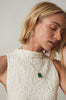 woman wearing emerald cut emerald gold necklace with cable link chain alongside gold earrings