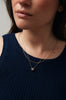 woman wearing gold necklace with rose cut salt and pepper diamond alongside other gold jewelry