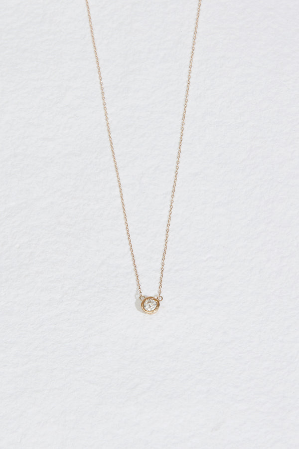 gold necklace with bezel set round white diamond