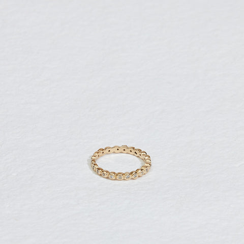 gold band with bezel set round white diamonds