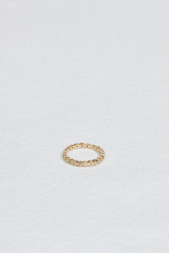 gold band with bezel set round white diamonds