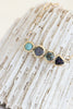 close up of gold necklace with round turquoise cabochon,  round labradorite, round blue topaz, and trillion blue sapphire