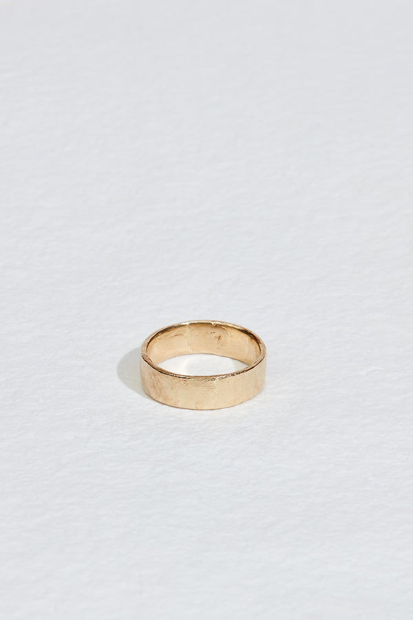 close up of men's thick gold band with straight edges