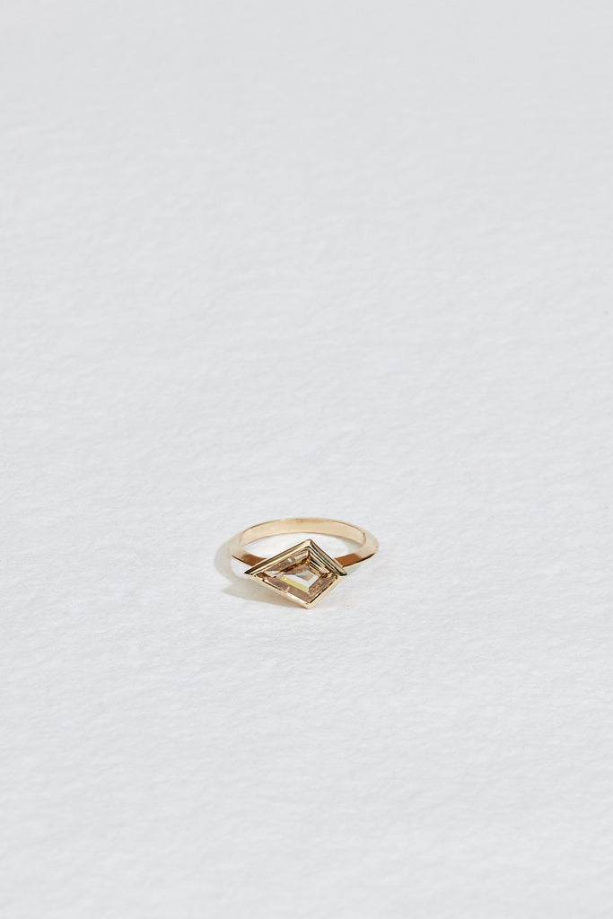 close up of gold band with bezel set yellow brown kite shaped diamond