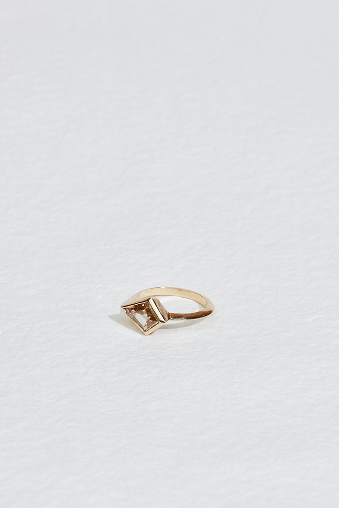 close up of gold band with bezel set yellow brown kite shaped diamond
