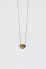 close up gold necklace with smokey oval sapphire