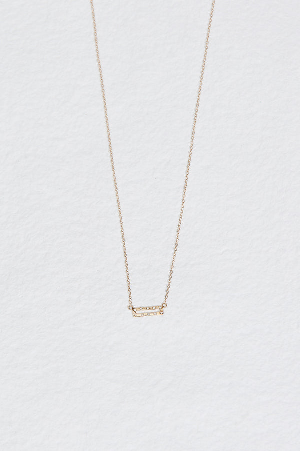 gold necklace with gold rectangle studded with round white diamonds