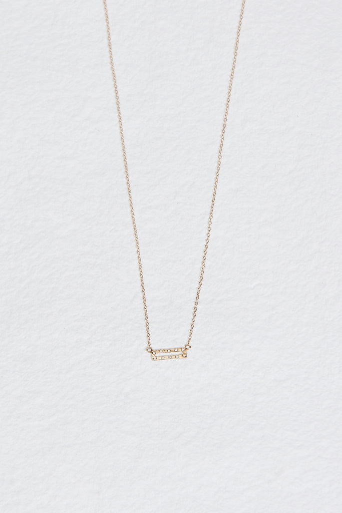 gold necklace with gold rectangle studded with round white diamonds