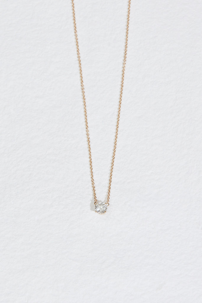 close up of gold necklace with round salt and pepper diamond