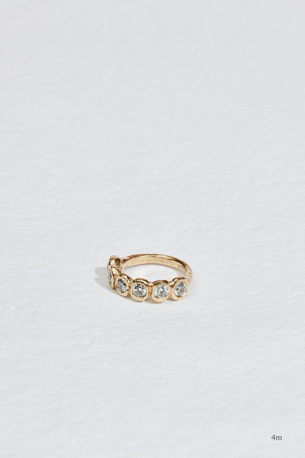 gold band with six bezel set round diamonds