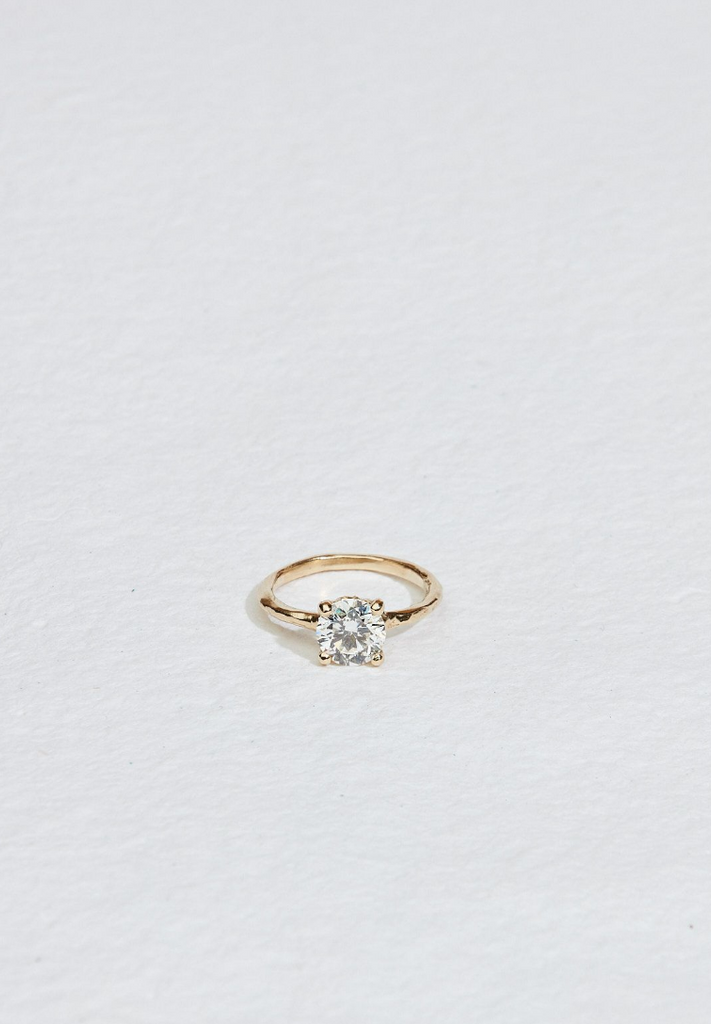 four prong gold ring with round white diamond