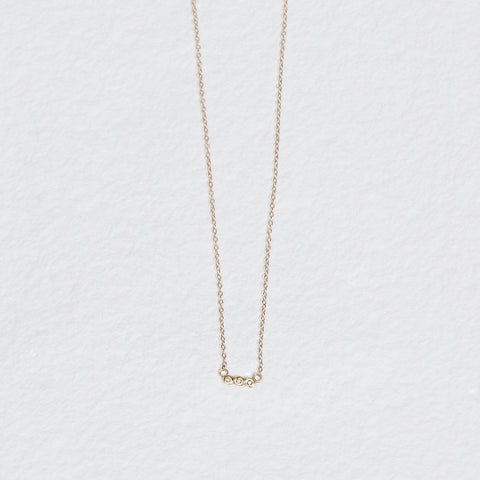 gold necklace with three bezel set round white diamonds
