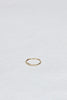 side view of thin gold textured band with round white diamond