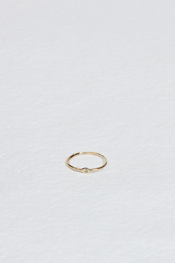 thin gold textured band with round white diamond
