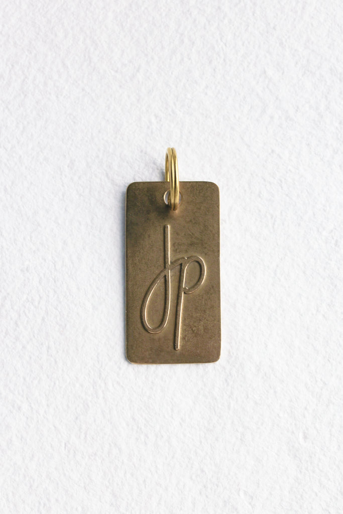 close up of bronze keychain with "JP" on it